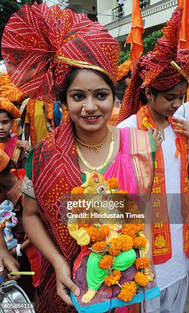 Girl carries Lord Ganesha idol in a procession before the idol immersion on the occasion of Anant Chaturdashi on September 15, 2016 in Bhopal, India.