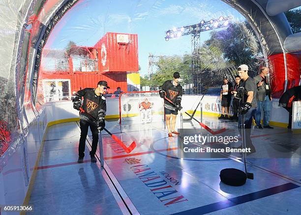 Johnny Gaudreau, Dylan Larkin and Ryan Nugent-Hopkins of Team North America play bubble hockey at the Scotiabank Fan Village prior to it's opening as...