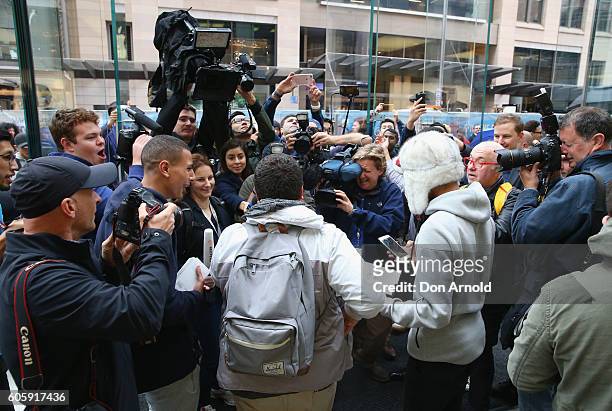 Media scrum forms around the young men who were the first to purchase the iPhone 7 as they pose with their phones at the Apple Store on September 16,...