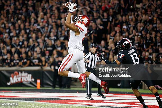 Chance Allen of the Houston Cougars leaps for a 39-yard touchdown reception against Grant Coleman of the Cincinnati Bearcats in the first half at...