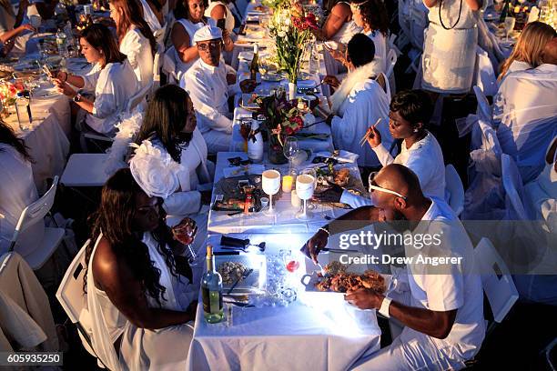 Diners sit down to eat their dinner during the annual 'Diner en Blanc' in Battery Park City, September 15, 2016 in New York City. Diner en Blanc was...
