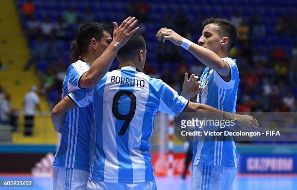 Cristian Borruto of Argentina celebrates after his goal with teammates Alamiro Vaporaki and Maximiliano Rescia during Group E match play between...