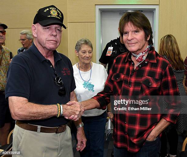 Military veteran Fred L. Herr and his wife Peggy Herr greet recording artist John Fogerty after he performed with Six-String Soldiers, a four-member...
