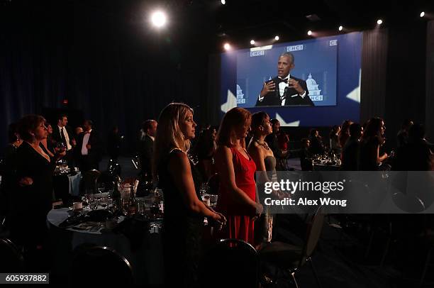 Guests watch U.S. President Barack Obama speaks on a big screen during the 39th annual awards gala of the Congressional Hispanic Caucus Institute...