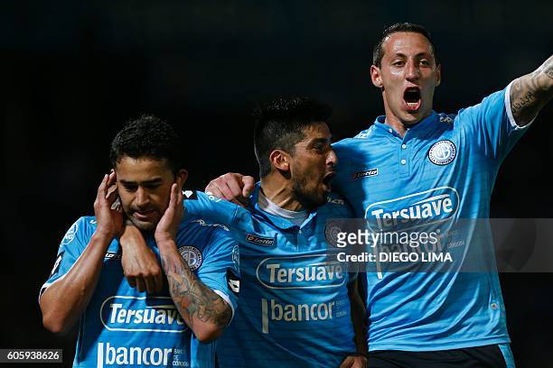 Forward Claudio Bieler of Argentina's Belgrano celebrates with his teammates, midfielder Jorge Velazquez and defender Cristian Lema after scoring a...