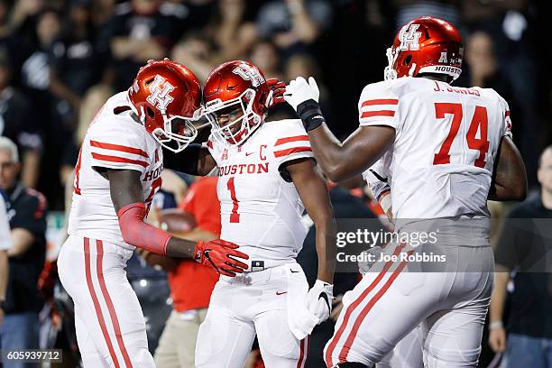 Greg Ward Jr. #1 of the Houston Cougars celebrates with teammates after rushing for a three-yard touchdown in the fourth quarter against the...