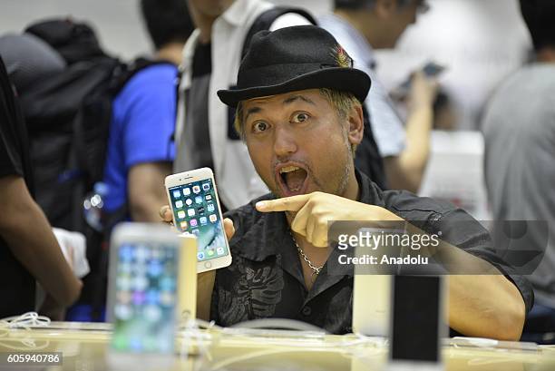First buyer customer pose with his new iPhone at a telecom shop in Omotesando Avenue in Tokyo, Japan on September 16, 2016. Apple has released for...