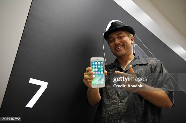 Customers inspects new iPhone models at a telecom shop in Omotesando Avenue in Tokyo, Japan on September 16, 2016. Apple has released for sale its...