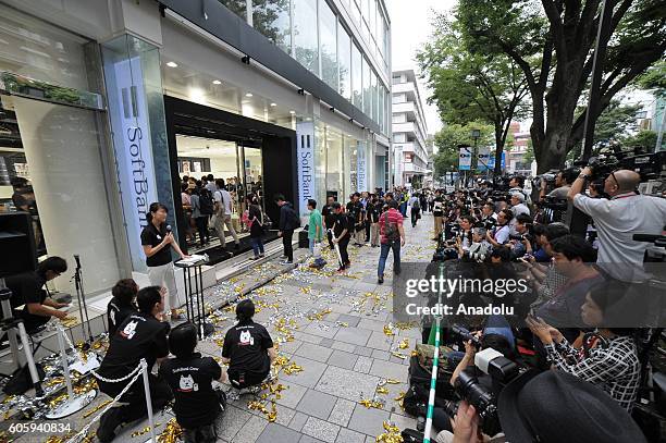 People wait in the queue in front of a telecom shop in Omotesando Avenue in Tokyo, Japan on September 16, 2016. Apple has released for sale its new...