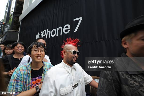People wait in the queue in front of a telecom shop in Omotesando Avenue in Tokyo, Japan on September 16, 2016. Apple has released for sale its new...