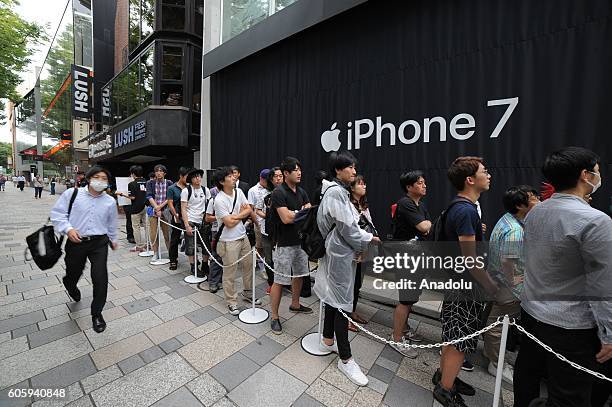 People wait in the queue in front of a telecom shop in Omotesando Avenue in Tokyo, Japan on September 16, 2016. Apple has released for sale its new...