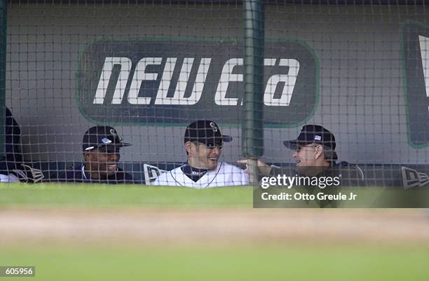 Ichiro Suzuki of the Seattle Mariners talks with team coach John McLaren and teammate Eugene Kingsale during the game against the Anaheim Angels at...