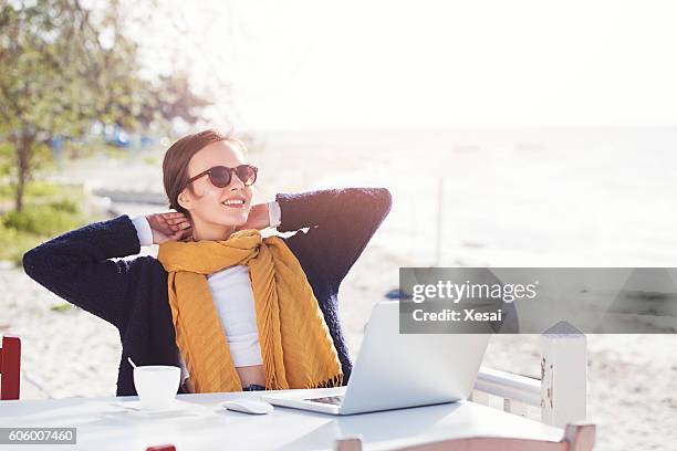 beautiful young woman outdoors with a laptop - worry free stock pictures, royalty-free photos & images