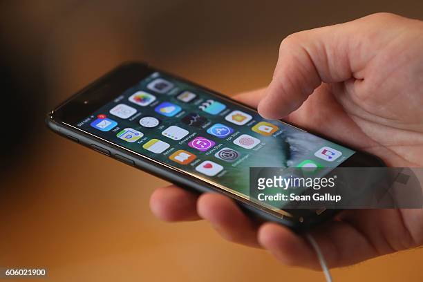 Visitor tries out an Apple iPhone 7 on the first day of sales of the new phone at the Berlin Apple store on September 16, 2016 in Berlin, Germany....