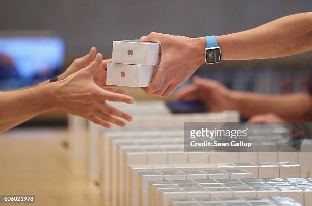 An Apple employee hands over Apple iPhone 7 phones on the first day of sales of the new phone at the Berlin Apple store on September 16, 2016 in...