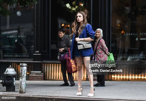 Xenia Tchoumi is seen wearing the Bill Cunningham inspired blue jacket by NYFW x Villency Design Group on the streets of Soho during New York Fashion...