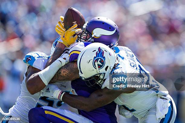 Kyle Rudolph of the Minnesota Vikings has a pass knocked away by Sean Spence and Da'Norris Searcy of the Tennessee Titans at Nissan Stadium on...