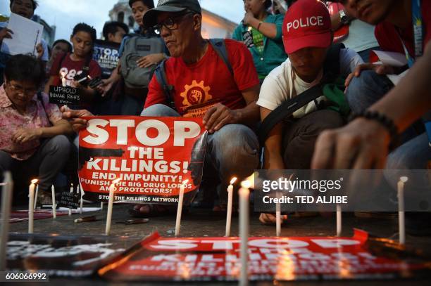 Activists light candles during the candle light vigil for victims of the extra judicial killings in the drug war of the government in front of a...