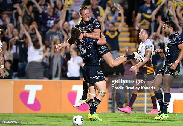 Michael Morgan of the Cowboys is congratulated by team mate Coen Hess after scoring a try during the first NRL semi final between North Queensland...