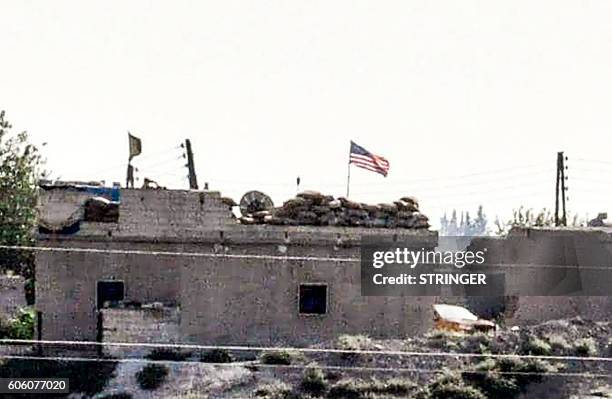 Picture taken from the Turkish side of the Syrian border in the Turkish town of Akcakale, in Sanliurfa, shows a US flag at the People's Protection...