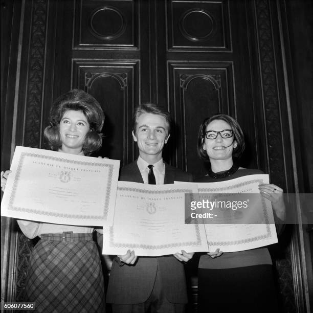 Picture released on November 22, 1963 of French singers Sheila , Claude François and Greek singer Nana Mouskouri holding their awards of the Academy...
