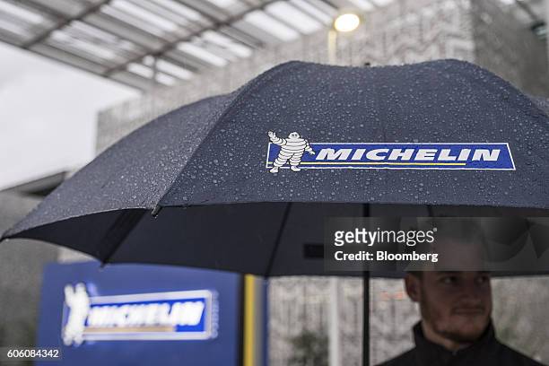 The Michelin & Cie. Bibendum mascot, also known as the Michelin Man, sits on an employee's umbrella as rain falls outside the new Michelin research...