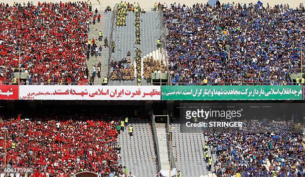 Esteghlal and Persepolis supporters cheer during their Persian Gulf Pro League derby football match between Persepolis FC and Esteghlal FC at the...