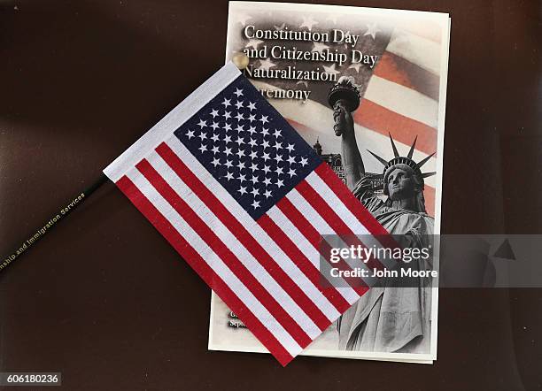 Program and U.S. Flag sit out before a naturalization ceremony on Ellis Island on September 16, 2016 in New York City. The ceremony marked U.S....