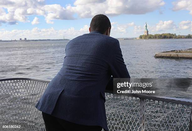 An immigrant looks towards the Statue of Liberty while in route to Ellis Island for a naturalization ceremony on September 16, 2016 in New York City....