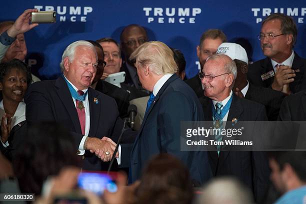 Republican presidential candidate Donald Trump greets Medal of Honor recipient Mike Thornton, left, during a campaign event with veterans at the...