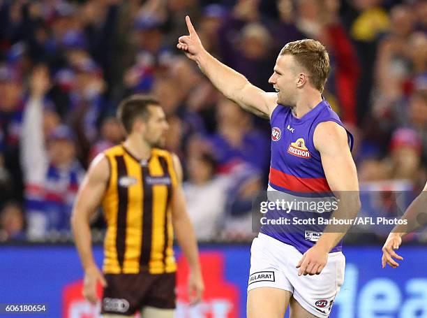 Jake Stringer of the Bulldogs celebrates after kicking a goal as Luke Hodge of the Hawks looks on during the second AFL semi final between Hawthorn...