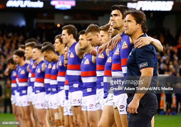 Luke Beveridge, Senior Coach of the Bulldogs lines up for the national anthem with his players during the 2016 AFL Second Semi Final match between...