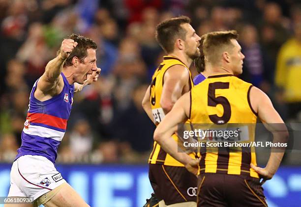 Joel Hamling of the Bulldogs and Dale Morris of the Bulldogs celebrate at the final siren as Sam Mitchell of the Hawks and Luke Hodge of the Hawks...