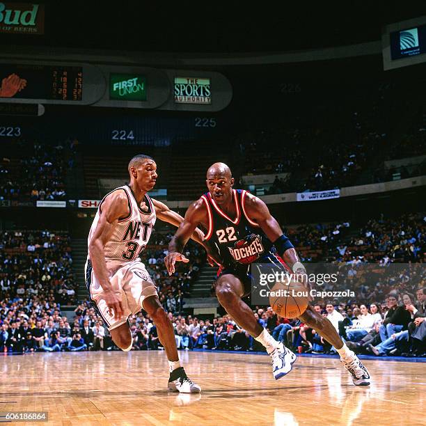 Clyde Drexler of the Houston Rockets drives to the basket while guarded by Kerry Kittles of the New Jersey Nets at Continental Airlines Arena in East...