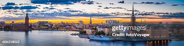 stockholm sunset spires city hall illuminated waterfront cityscape panorama sweden - stockholm stockfoto's en -beelden