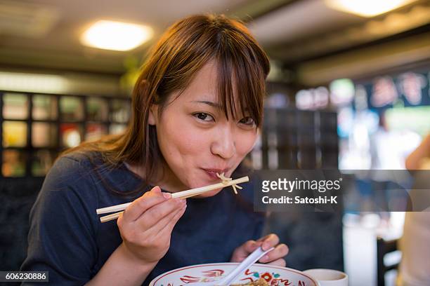 young woman eating ramen noodle in old japanese restaurant - ramen noodles 個照片及圖片檔