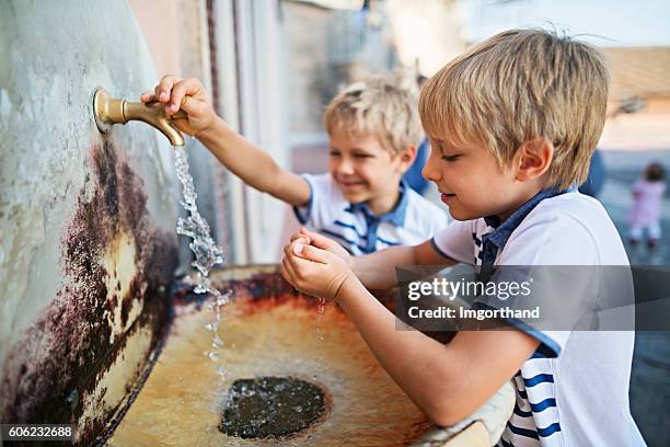 little bosy drinking tap water from publish sink - drinkwaterfontein stockfoto's en -beelden