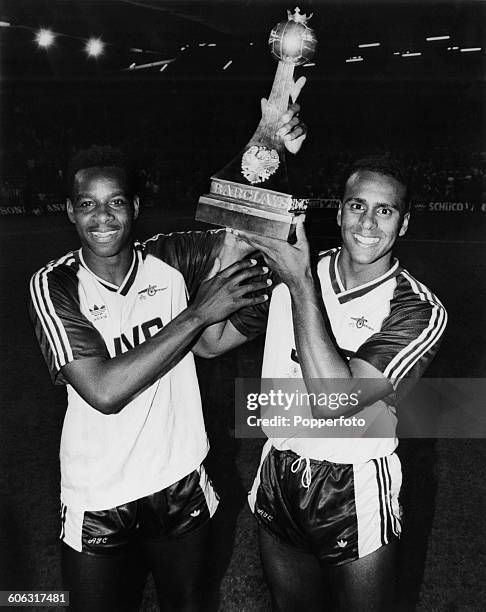 English footballers Michael Thomas and David Rocastle of Arsenal FC, holding up the trophy after their team beat Liverpool FC at Anfield, to win the...