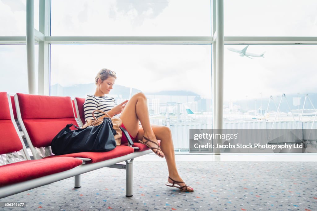 Caucasian woman using cell phone in airport