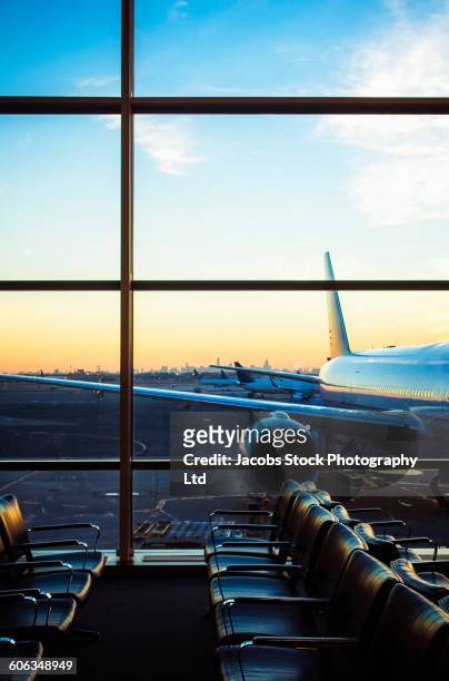 airplane viewed through window at airport gate - washington dc sunset stock pictures, royalty-free photos & images