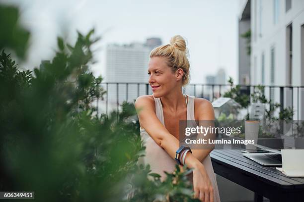 caucasian woman sitting on balcony - una mujer de mediana edad solamente fotografías e imágenes de stock