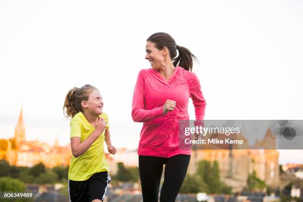 caucasian mother and daughter jogging outdoors - daily sport girls stock-fotos und bilder