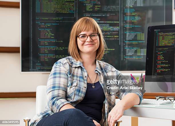 caucasian businesswoman smiling at computer - woman coding foto e immagini stock