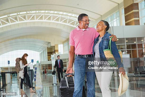 couple hugging in airport - black purse fotografías e imágenes de stock