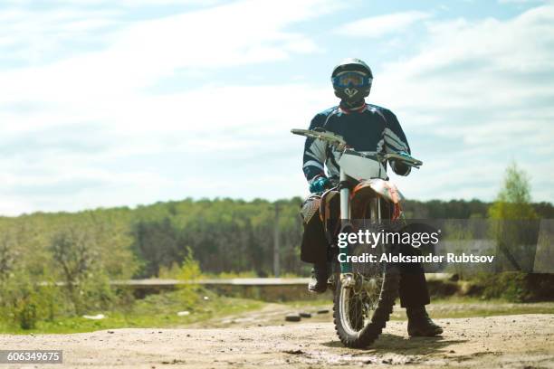 caucasian man riding dirt bike in field - motocross imagens e fotografias de stock
