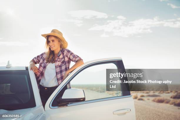 hispanic woman standing in car on remote road - car isolated doors open stock pictures, royalty-free photos & images