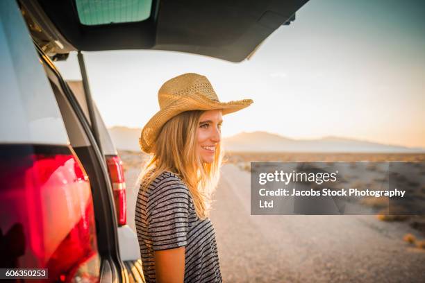 hispanic woman at car on remote road - california road trip stock pictures, royalty-free photos & images