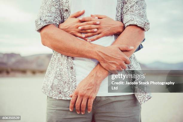 hispanic couple hugging in remote desert - woman waist up isolated stock pictures, royalty-free photos & images