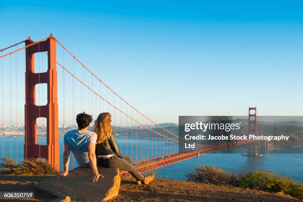 hispanic couple admiring golden gate bridge, san francisco, california, united states - são francisco califórnia imagens e fotografias de stock