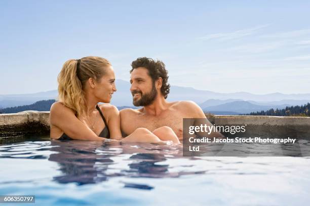 hispanic couple sitting in pool - woman in hot tub stock pictures, royalty-free photos & images
